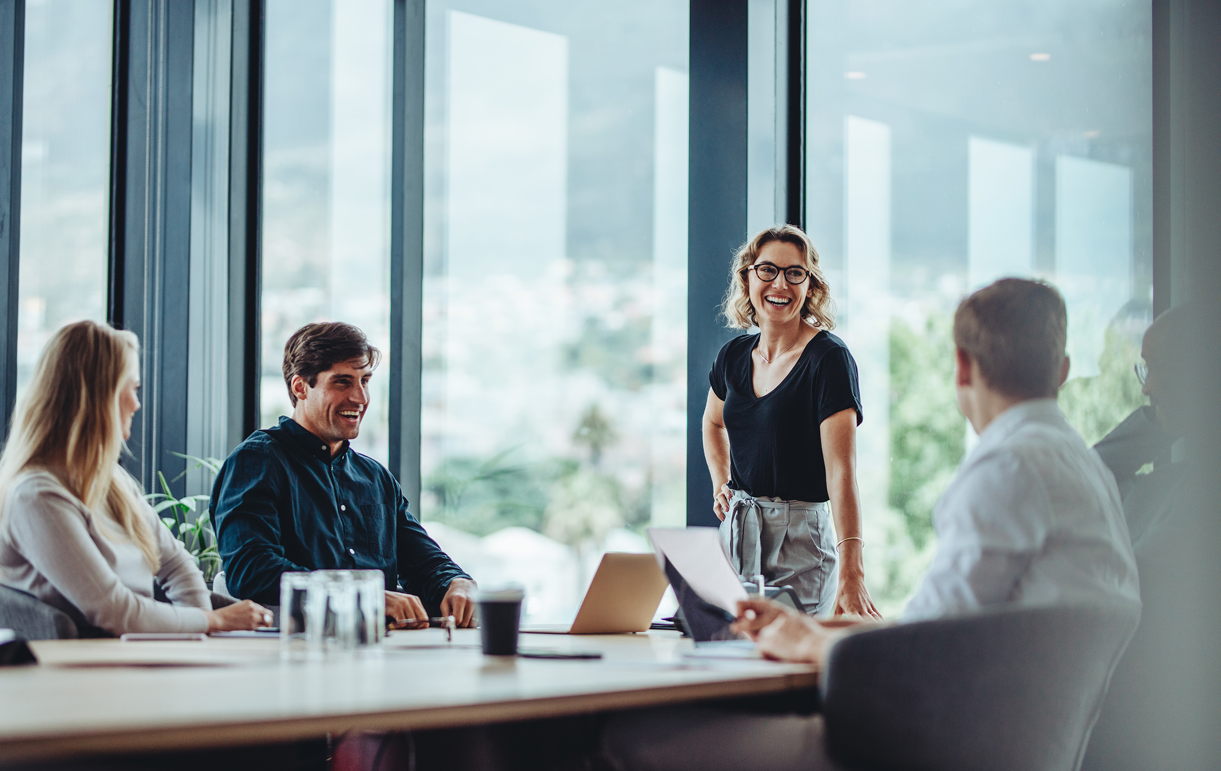 a team working together and smiling at a table in an office environment